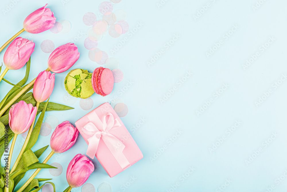 View from above tulips and gift box with copy space on blue. Background for womens day, 8 March Valentine's day, 14 february. Flat lay style, top view, mockup, template, overhead. Greeting card