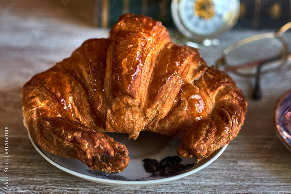 Classic breakfast with juicy croissant on a white plate