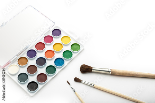 Watercolor paint on a white background, with brushes