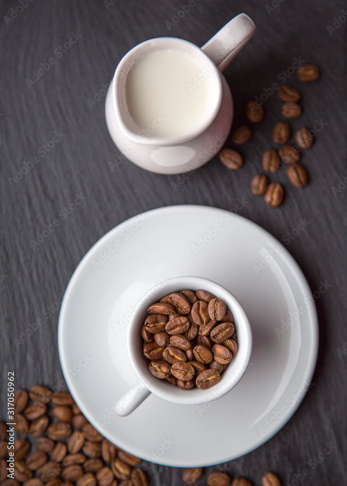 Cup of Coffee Beans with Milk on Grey Black Background Top View Natural Light Selective Focus.