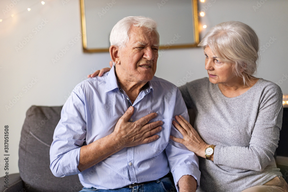 Senior woman helping her husband with chest pain Senior woman helping her husband with chest pain