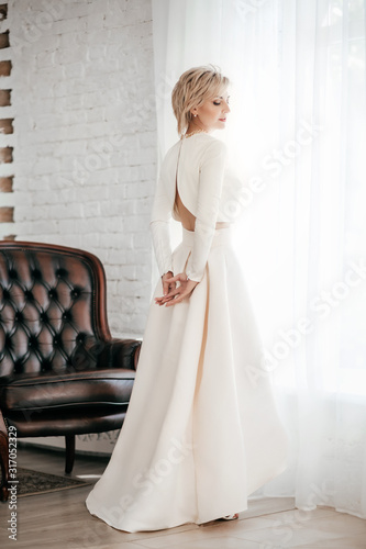 Portrait of beautiful young blonde woman with makeup in fashion white clothes