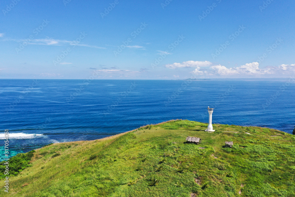 Basot Island, Caramoan, Camarines Sur, Philippines. Lighthouse on a hill by the sea, view from above . Beautiful landscape with a green island. Summer and travel vacation concept.