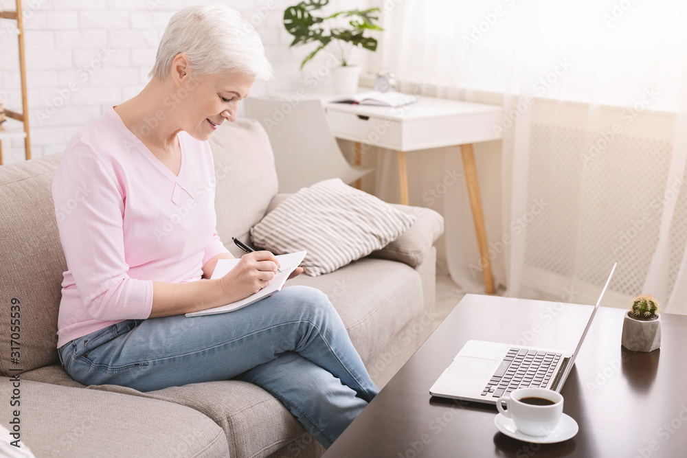 Well organized senior lady writing to-do-list at home Well organized senior lady writing to-do-list at home