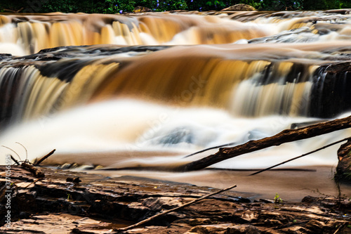 cachoeira com águas de tonalidade marrom devido a fortes chuvas criando sensação de areia photo