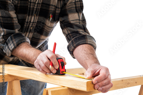 Close-up. Carpenter with pencil and the meter marks the measurement on a wooden board. Construction industry. White background.