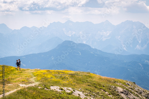 Hiking couple on mountain Hochobir, Austria, with Kamnik–Savinja Alps photo