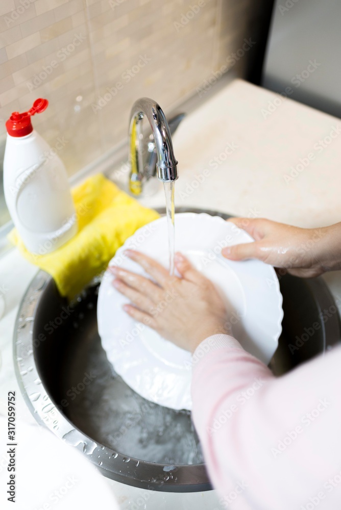woman washing dishes in kitchen