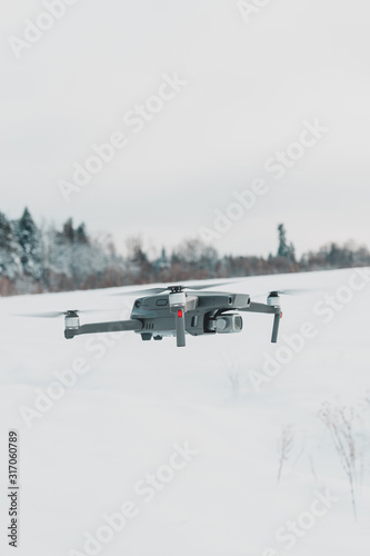 Running drone into the sky, quadcopter on blue sky background.