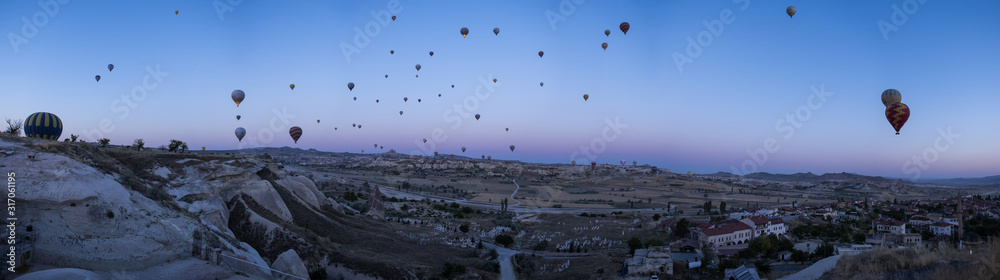 Cappadocia, Turkey, Europe: hot air balloons floating at dawn and view of the valley around Cavusin, town of the historical region in Central Anatolia rich of exceptional natural wonders