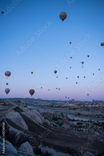 Cappadocia, Turkey, Europe: hot air balloons floating at dawn and view of the valley around Cavusin, town of the historical region in Central Anatolia rich of exceptional natural wonders