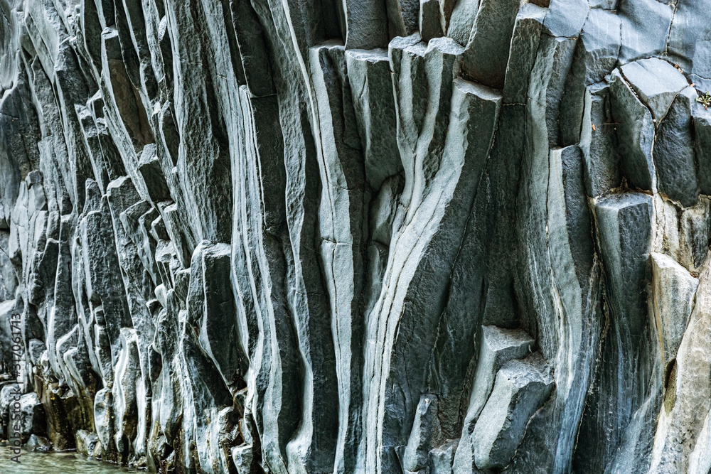Wall of volcanic lava of Mount Etna. Texture of stone is dark gray colored. Natural background. Wall of volcanic lava of Mount Etna. Texture of stone is dark gray colored. Natural background.
