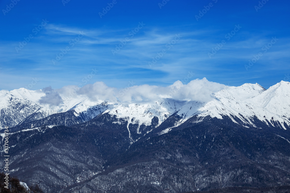 Beautiful panoramic view snow capped mountains, Russian beautiful winter mountains. Slope for cross country skiers and bright sun.