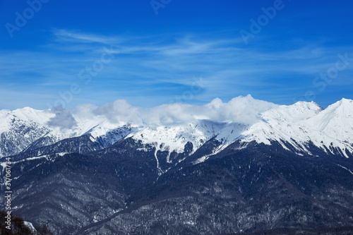 Beautiful panoramic view snow capped mountains, Russian beautiful winter mountains. Slope for cross country skiers and bright sun. © yrabota