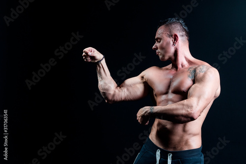 Male bodybuilder with an athletic build on a dark background.athlete, exercise, health, power, strength, man,