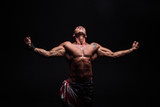 Male bodybuilder with an athletic build on a dark background. athlete, exercise, health, power, strength, man,