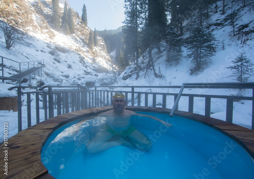 man in hot baths with thermal waters in the mountains in winter