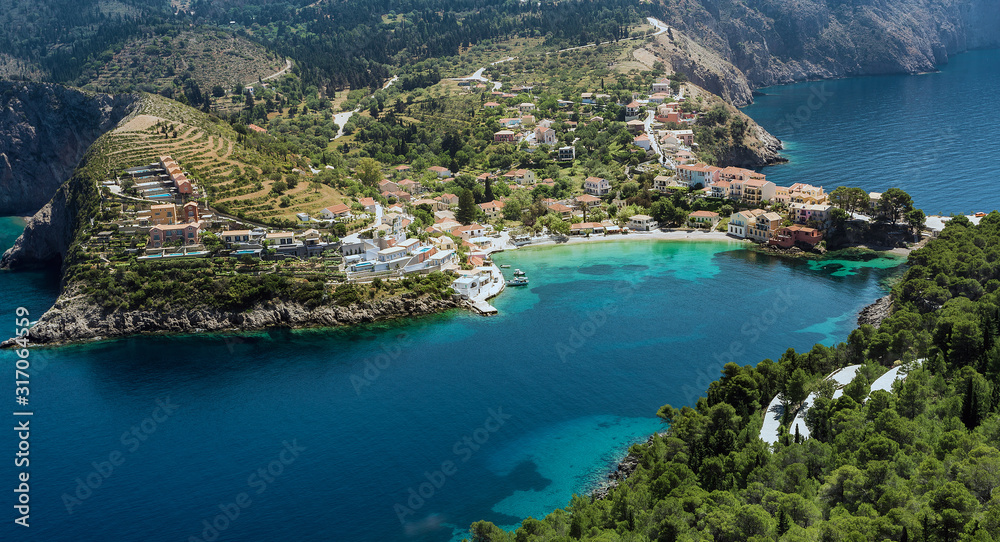 Wonderful summer seascape of Ionian Sea. Wonderful place for holiday. Amazing Greece. Picturesque colorful village Assos in Kefalonia. Turquoise colored bay in Mediterranean sea. Aerial view.