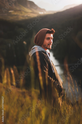 joven en el atardecer con pastos altos y luz calida