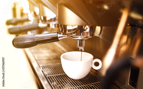 Black coffee morning on coffee maker. Coffee machine preparing fresh coffee and pouring into cups at restaurant, bar or pub. Professional brewing. Preparation service concept.