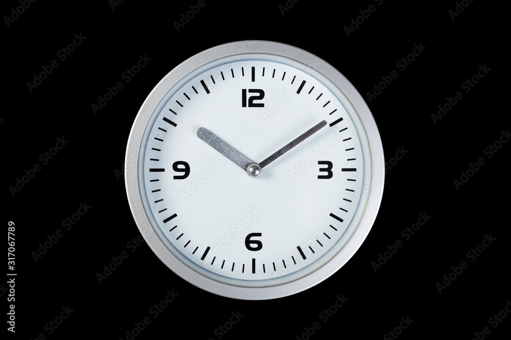 White wall clock with a yellow used hanging on the wall. Minimalist image of a wall clock on a black background with copy space White wall clock with a yellow used hanging on the wall. Minimalist image of a wall clock on a black background with copy space
