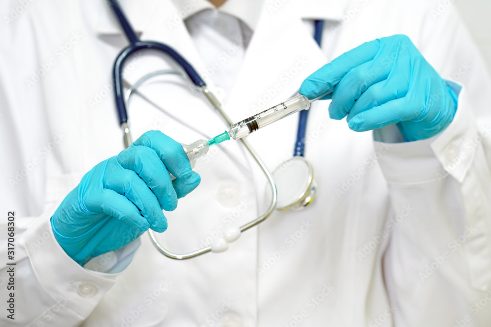Female doctor with vaccination injection syringe in hand in gloves and stethoscope. Female doctor with vaccination injection syringe in hand in gloves and stethoscope.