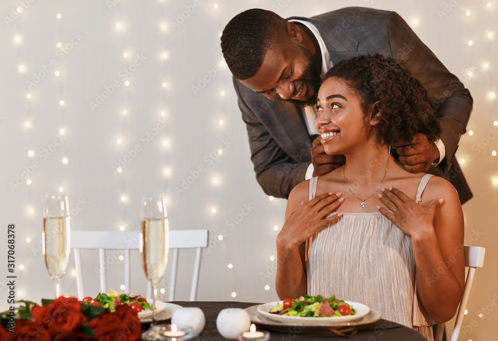 Loving black man giving woman elegant necklace Loving black man giving woman elegant necklace
