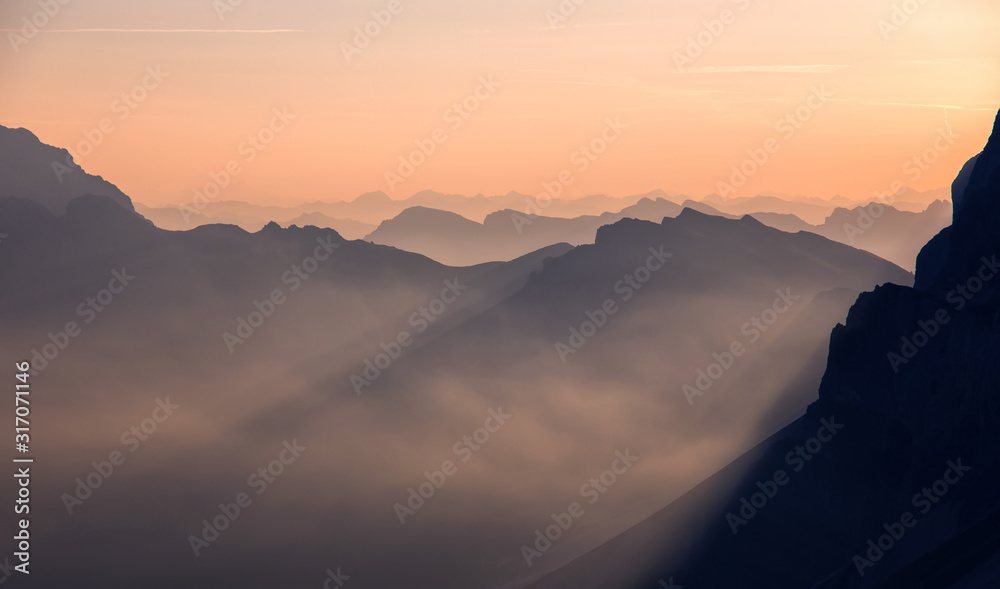 Fototapeta premium Fantastic misty morning in the dolomites Alps. landscape with colorful misty silhouettes of mountains with rays . Nature background, scenery. Awesome alpine highlands during sunset. Shot from Seceda