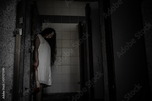 Portrait of asian woman make up ghost face,Horror scene,Scary background,Halloween poster,Ghost holding axe
