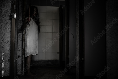 Portrait of asian woman make up ghost face,Horror scene,Scary background,Halloween poster,Ghost holding axe