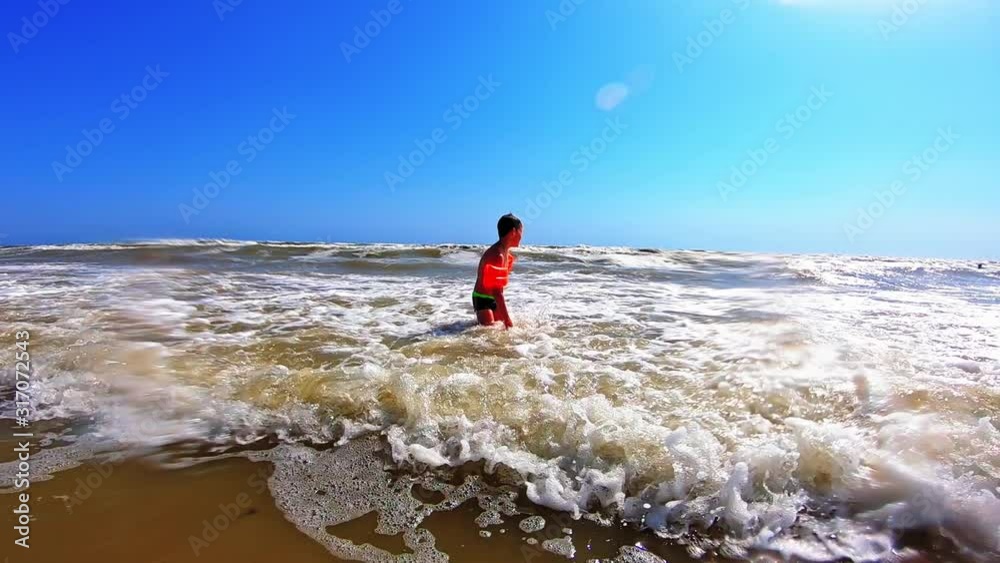 Boy playing on beach. Happy boy playingin sea water