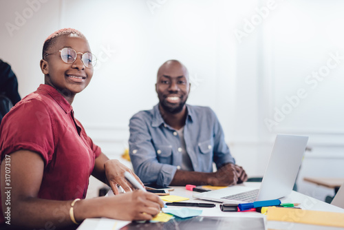 Happy African American coworkers working at task at office