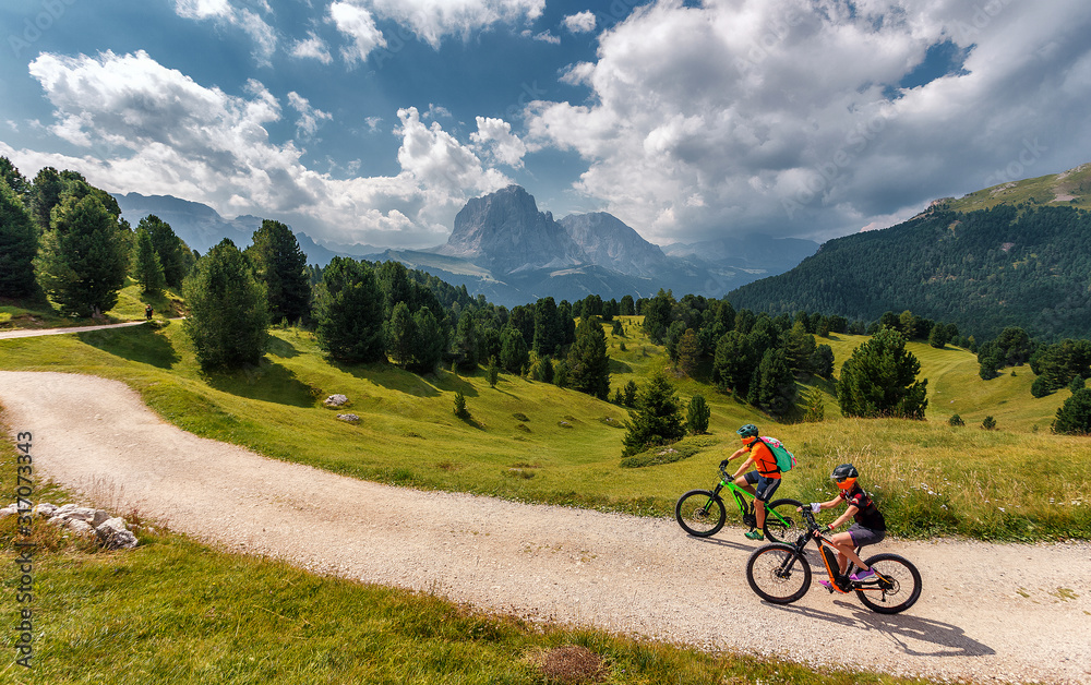 Wonderful Nature Landscape. Mountain biking couple with bikes on track. Val Gardena. Dolomites Alps. Italy. Travel Lifestyle wanderlust adventure concept. Outdoor wilderness vacations.