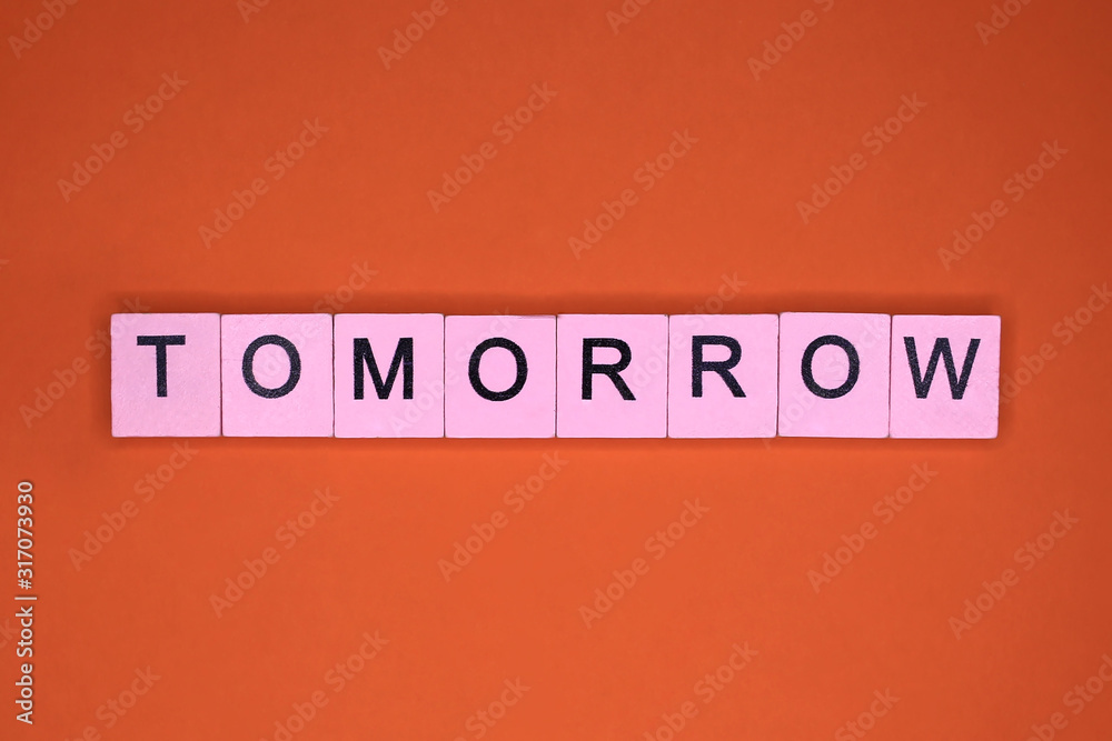 Tomorrow word wooden cubes on an orange background. Tomorrow word wooden cubes on an orange background.