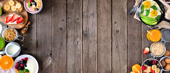 Healthy breakfast food banner with double border. Table scene with fruits, yogurt, smoothie bowl, nutritious toasts, oatmeal and egg skillet. Top view over a rustic wood background. Copy space.