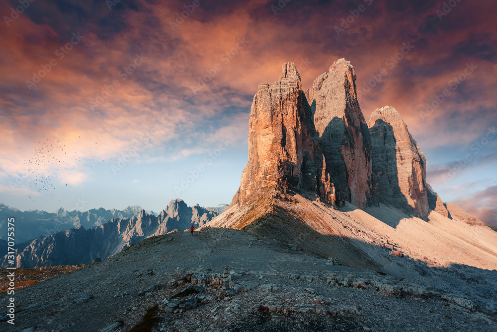 Tipical postcard. Majestic Tre peaks di Lavaredo during sunset, with colorful clouds under sunlight. Dramatic Picturesque scene. fairytale Tre Cime di Lavaredo national park in Italy, Dolomites Alps.