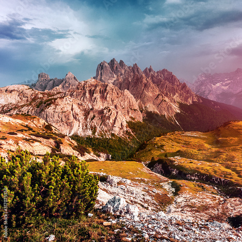 Fantastic spring landscape during sunset. Colorful sky glowing by sunlight. Dramatic morning scene. Majestic Dolomites Rock mountains under warm sunlit. Tre Cime di Lavaredo park. Dolomite Alps. Italy