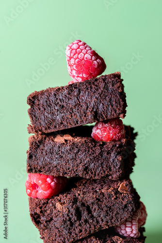 Fotografie Stack of brownies with frozen raspberries. Chocolate cake pile