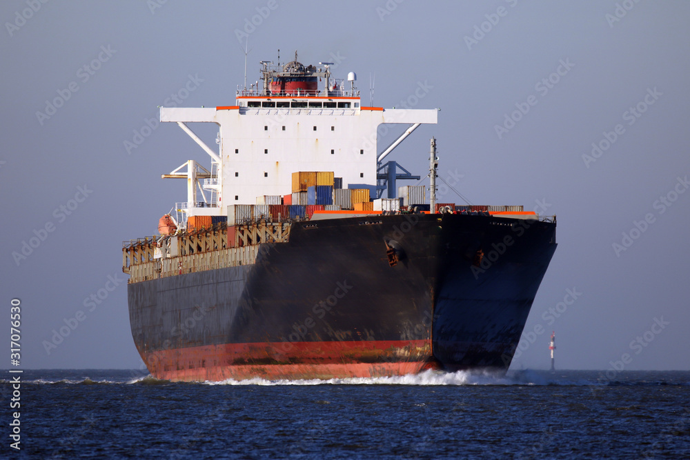 schwarzes Containerschiff von vorne