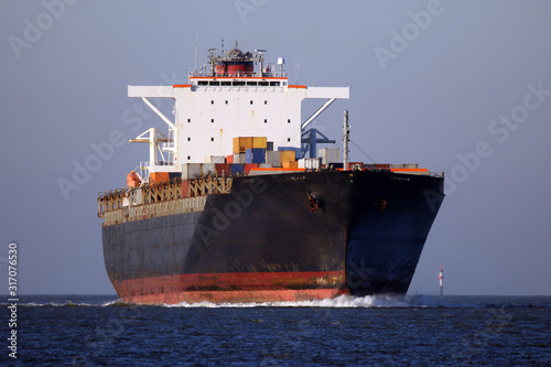 schwarzes Containerschiff von vorne