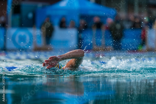 Woman swimming freestyle in an outdoor pool at an ice swimming event