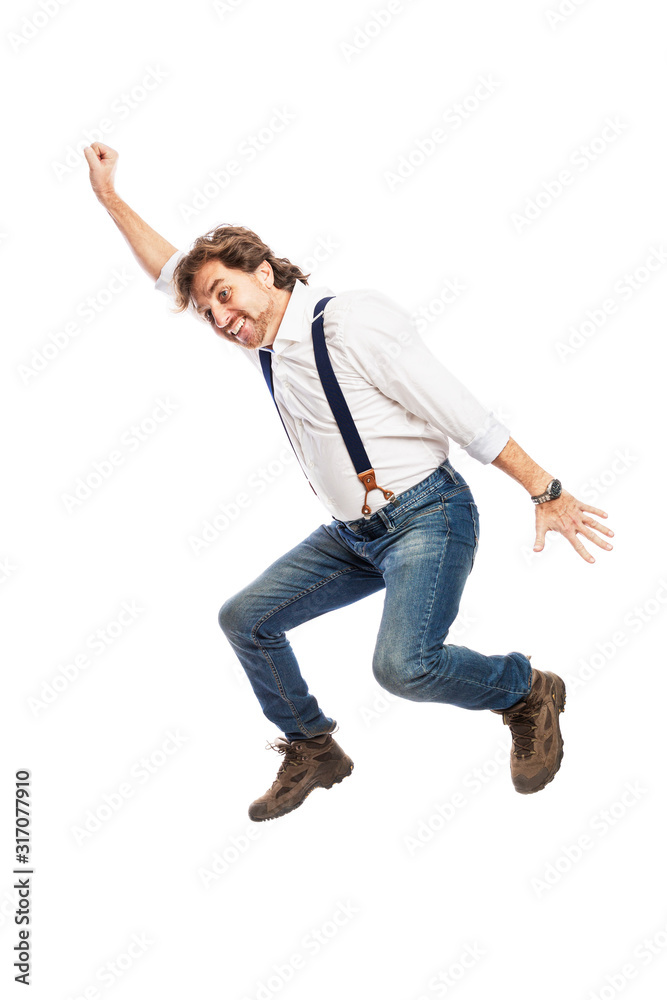 A smiling pretty redhead man with a beard in jeans and a white shirt is jumping. Isolated over white background. Vertical.