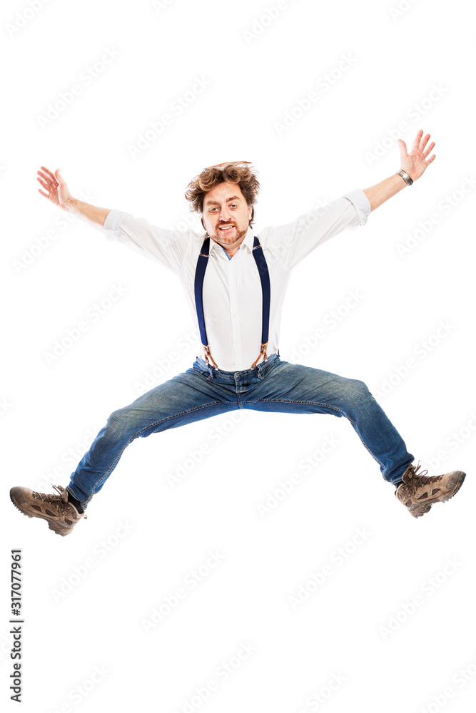 A smiling pretty redhead man with a beard in jeans and a white shirt is jumping. Isolated over white background. Vertical. A smiling pretty redhead man with a beard in jeans and a white shirt is jumping. Isolated over white background. Vertical.