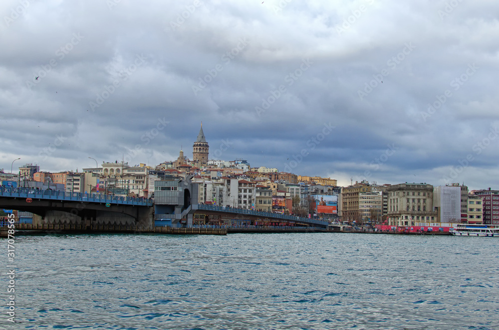 Istanbul, Turkey-January 03, 2020: Picturesque landscape view of Istanbul. The Galata Bridge over the Golden Horn in Istanbul. The Galata Tower (Christea Turris) at the top of the hill