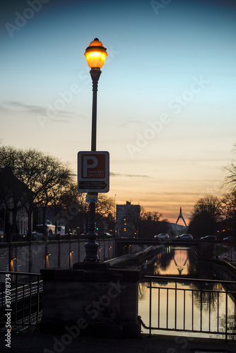 closeup of illumined street light on street silhouettes background by sunset