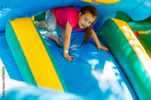Fotografija Little Girl sliding down an inflatable Slide