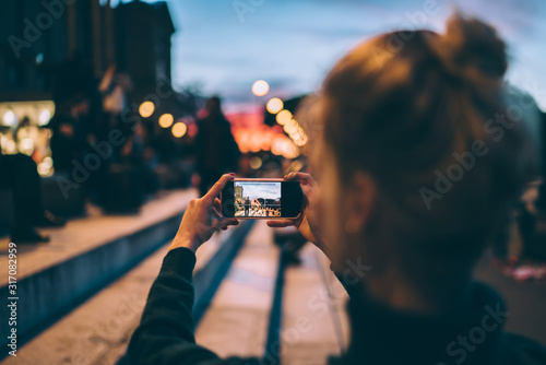 Back view of female generation photographing city urban setting during journey getaway connected to 4g wireless for sharing pictures to social media website, millennial woman taking images via camera photo