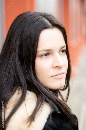 Close-up portrait of an attractive young brunette woman looking away