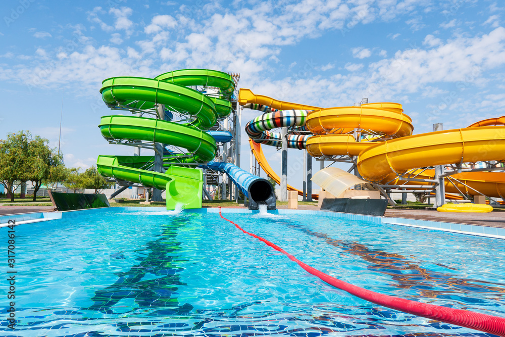 Outdoor water park. Multi-colored slides and pools. - obrazy, fototapety, plakaty 