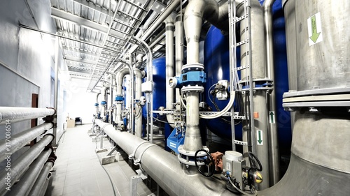 New shiny pipes, large pumps in industrial boiler room, close-up. Industry, technology, special equipment, water treatment, pure drinking water, biotechnology, chemistry, ecology, environmental damage photo